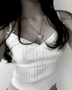 black and white photograph of a woman with long dark hair wearing a tank top, holding her hand on her hip