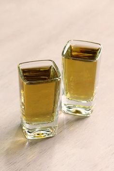 two shot glasses sitting on top of a wooden table