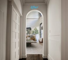 an archway leading into a living room with hardwood flooring and walls painted in white