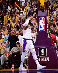 a basketball player is holding his arms up in the air as he walks off the court