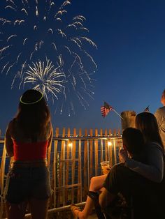 people watching fireworks on the beach at night