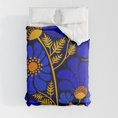 a bed with blue and yellow floral designs on it's side, next to a white pillow