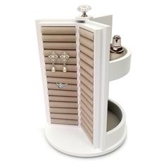 an open white box with earrings and rings in it on a stand against a white background