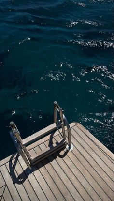 a chair sitting on top of a wooden dock next to the ocean