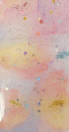 an abstract painting with gold, pink and blue paint sprinkles on it