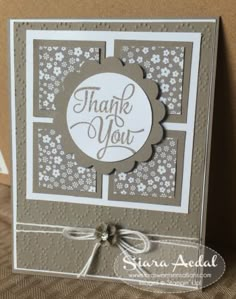 a thank card with the words thank you in white and gray on it, sitting on top of a table