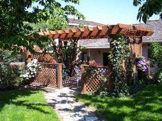 a small house with a wooden pergolan on the front yard