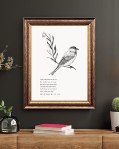 a bird sitting on top of a wooden table next to a plant and book shelf