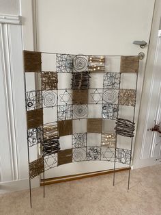 a metal sculpture with squares and circles on it's sides in front of a door