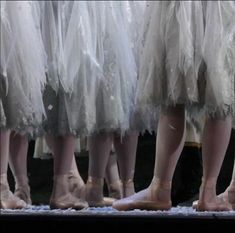 several pairs of ballet shoes with tulle skirts