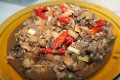 a yellow plate topped with rice covered in mushrooms and peppers on top of it's side