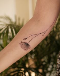 a woman's arm with a flower tattoo on it