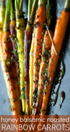 some carrots are sitting on a table with the words, honey balsamic roasted rainbow carrots