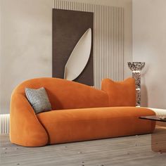 an orange couch sitting on top of a hard wood floor next to a tall mirror