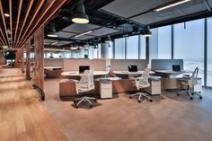 an office with wooden flooring and large windows looking out to the ocean on a sunny day