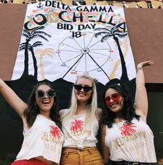 three women are standing in front of a sign that says, delta gama o'chella bid day