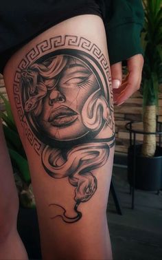 a woman's thigh with a tattoo design on the leg and her face in an ornate frame