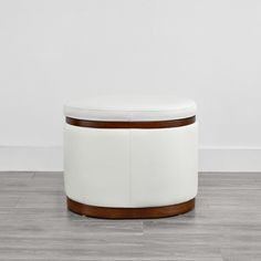 a white ottoman sitting on top of a hard wood floor