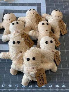 a group of stuffed animals sitting on top of a table next to a measuring ruler