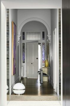 an entry way with white walls and wooden floors