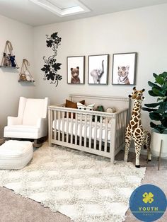 a baby's room with a giraffe, chair and pictures on the wall