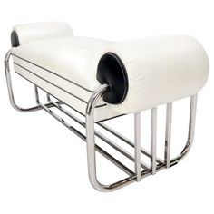 a white leather bench with chrome legs and a magazine rack on the backrests