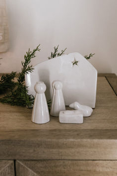 a couple of white figurines sitting on top of a wooden table