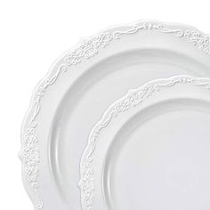 three white plates with ornate designs on them, one is empty and the other has an empty