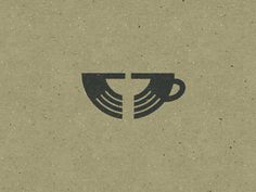 a coffee cup with the letter t on it's side, in front of a brown background