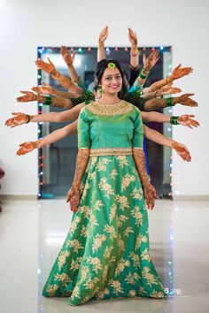 two women dressed in green and gold are posing for the camera with their arms outstretched