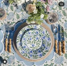 the table is set with blue and white plates, silverware, and napkins