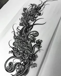 an intricately designed piece of paper on top of a white sheet with black ink