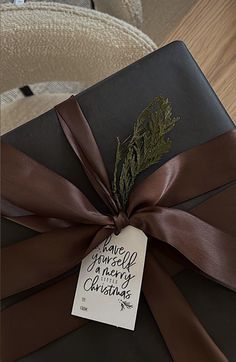 a present wrapped in brown ribbon with a tag on it