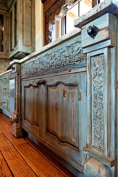 an old fashioned kitchen with wood floors and blue cabinetry on the side, along with hardwood flooring