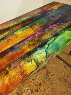 a bench made out of colorful paint sitting on top of a floor