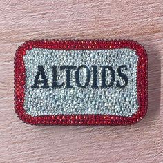 a red and white sign with the word altoids on it's back side