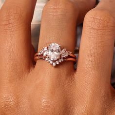 a woman's hand with an engagement ring on top of her finger and the other hand holding it