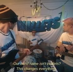 two young men are playing guitars in front of a sign that says, our band name isn't walls? this changes everything