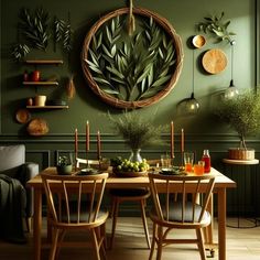 a dining room with green walls and wooden table set for two, surrounded by greenery hanging on the wall