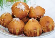 a pile of muffins sitting on top of a plate covered in powdered sugar