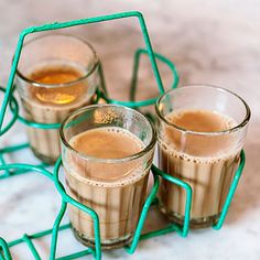 three glasses filled with liquid sitting on top of a marble counter next to each other