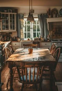 a wooden table sitting in the middle of a kitchen next to a stove top oven