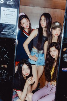 four girls are posing in front of a sign