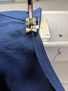 the sewing machine is working on the blue fabric