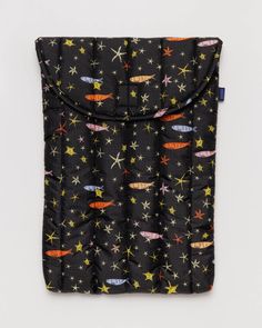 a black bag with colorful stars and planets on it's front pocket, sitting on a white surface