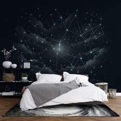 a bedroom with a bed, night sky and stars on the wall behind it is a black background