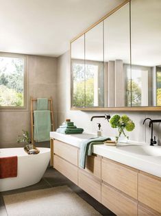 a bath room with a tub a sink and mirrors