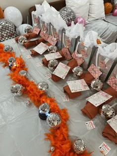 a table topped with lots of silver and orange decorations