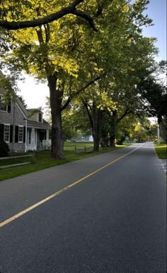 an empty street lined with houses and trees