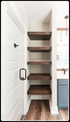 an empty walk in closet with shelving and wood flooring on the side wall